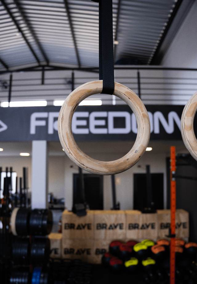 Argolas de ginástica com o letreiro Freedom ao fundo